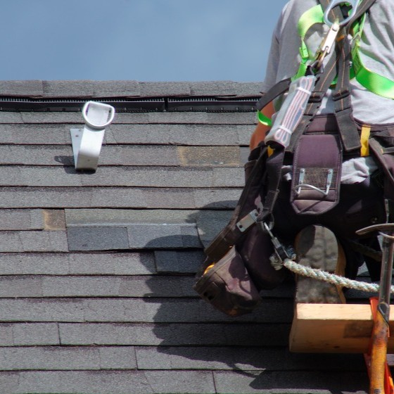 Close-up view of asphalt shingles being repaired on home