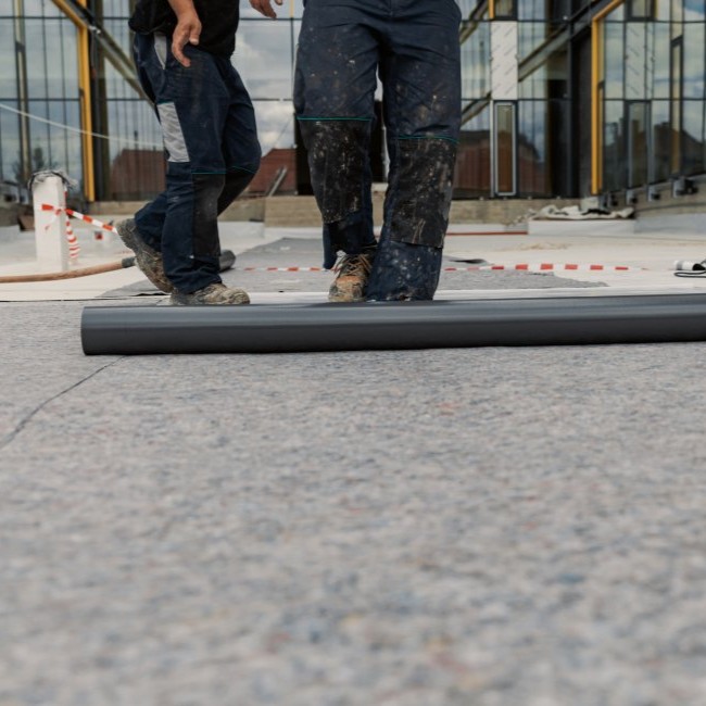 White EDPM roofing being installed on building